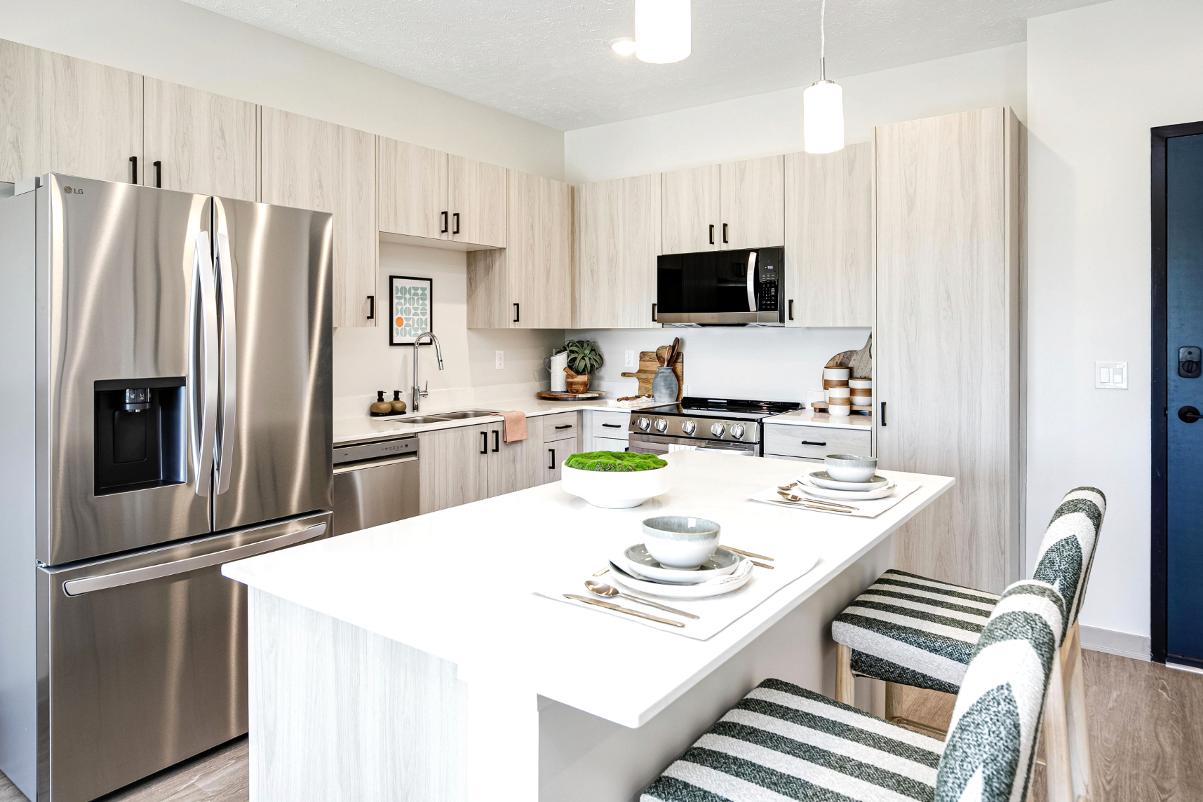 Kitchen with island, light wood cabinets and stainless steel appliances