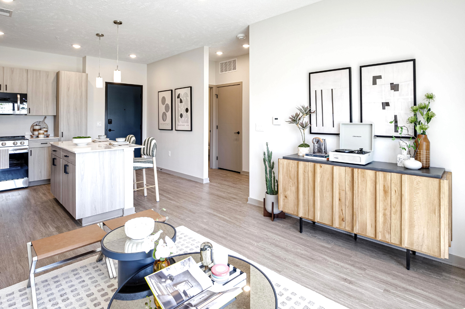 Wide view of living area with coffee table and view into kitchen with island