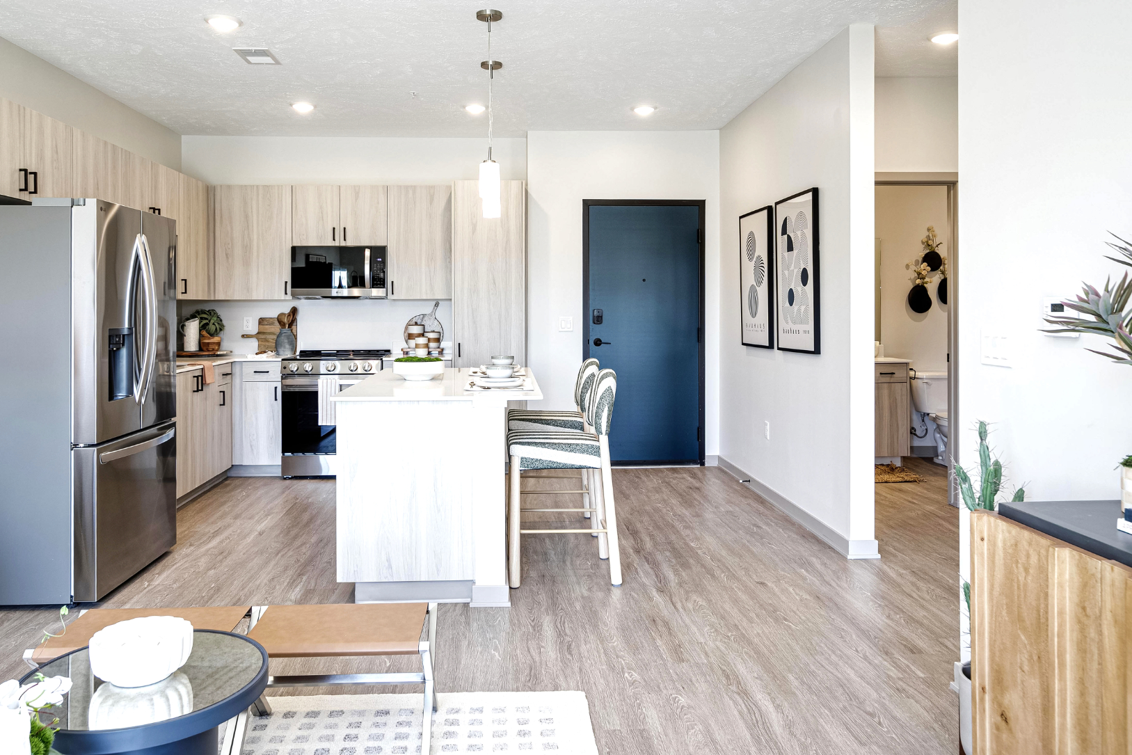 Wide view of living ad dining area into kitchen with island