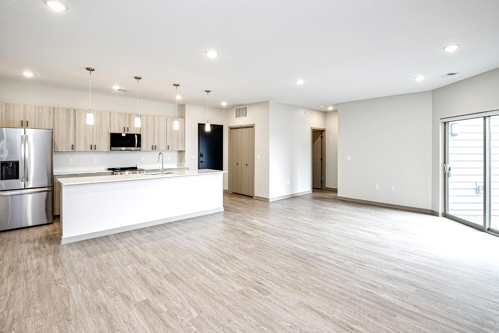 Wide view of living area unfurnished with kitchen 