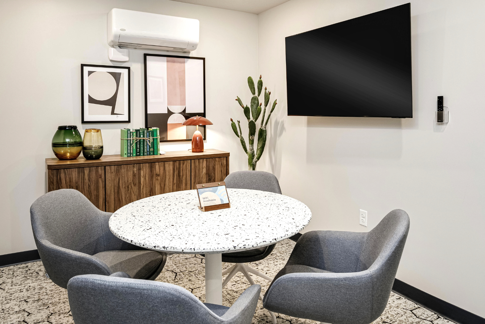 Clubhouse private workspace with table, chairs, and tv