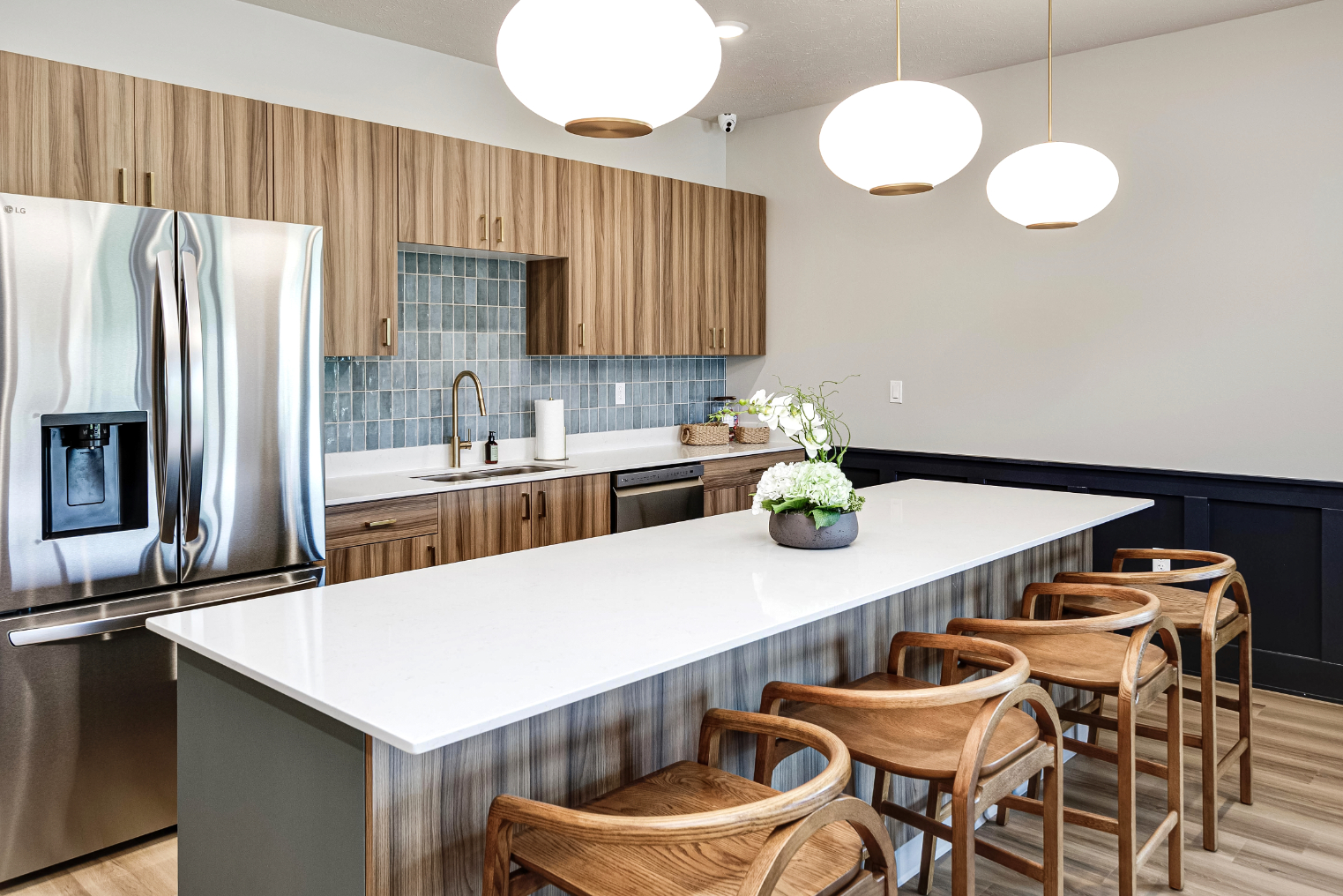 Clubhouse kitchen with island, chairs, and stainless steel appliances
