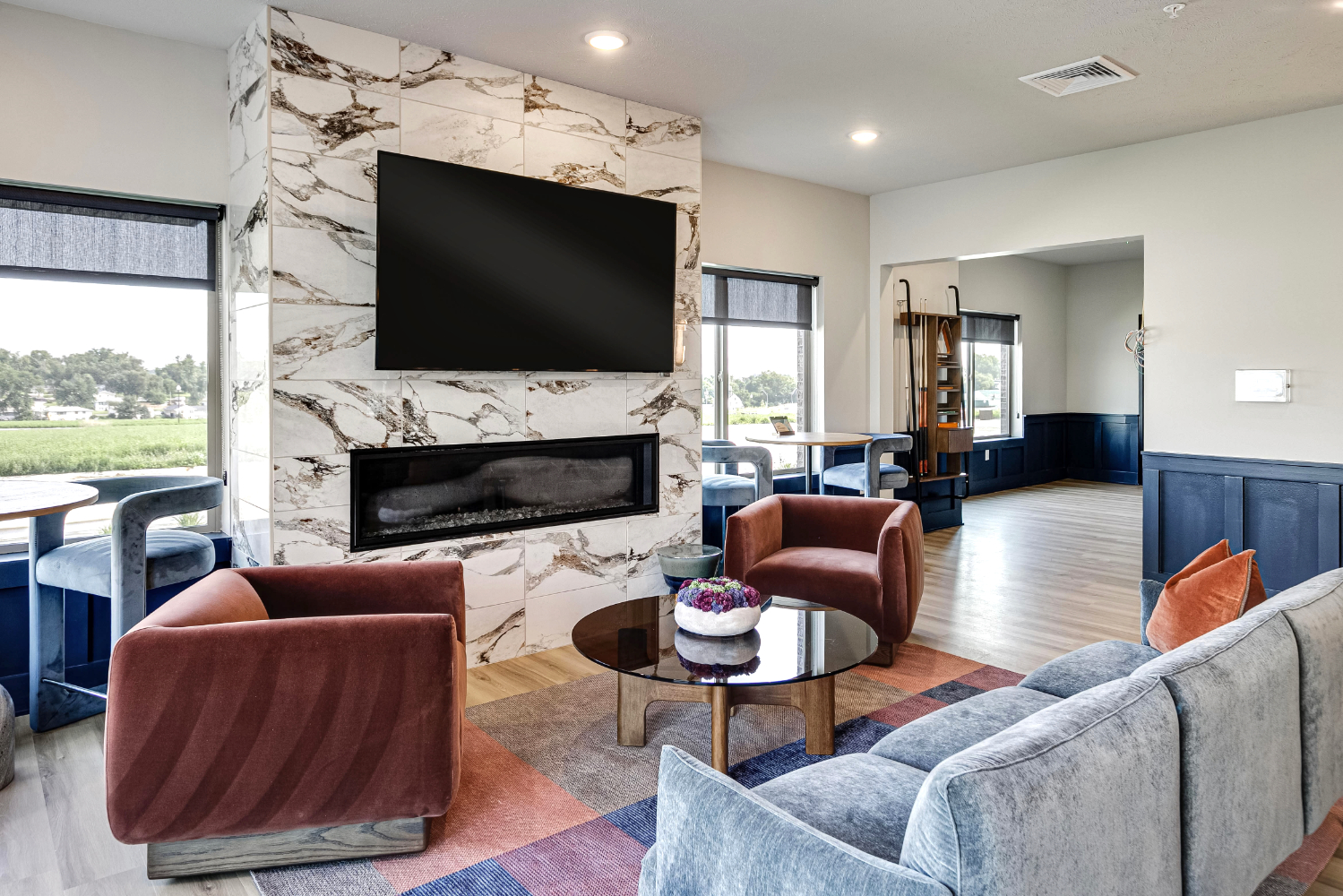 Clubhouse lounge area with chairs, tv, and fireplace