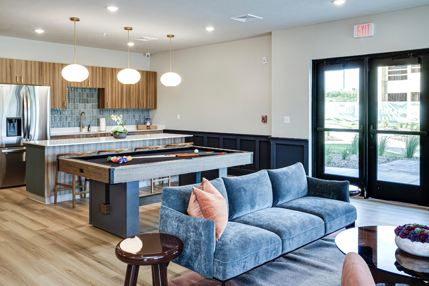 Clubhouse lounge area with view of kitchen and billiards table