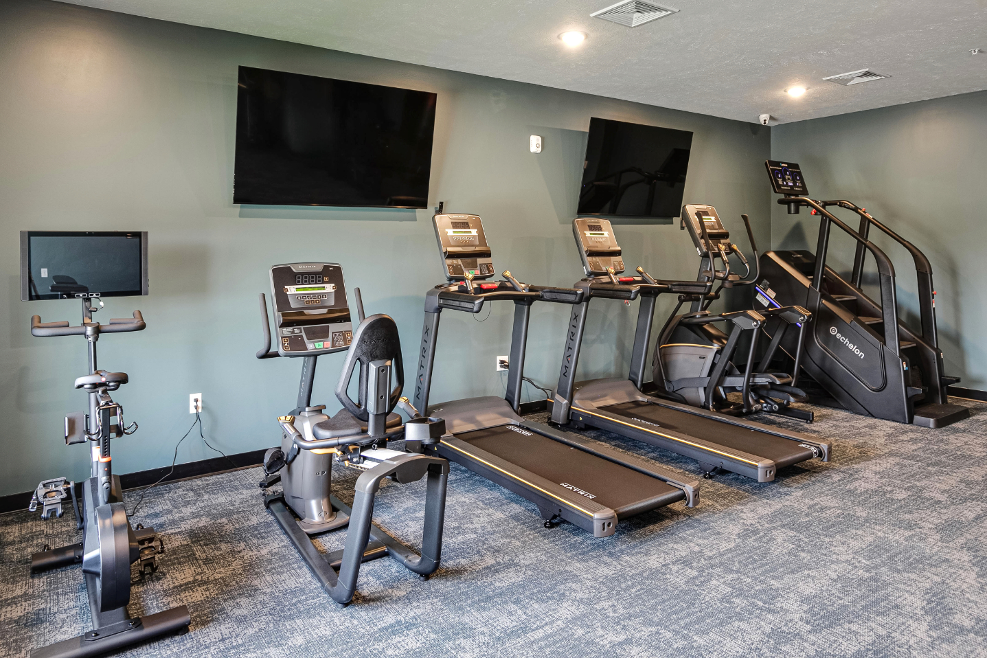 Clubhouse gym with treadmills, stair master, and stationary bike