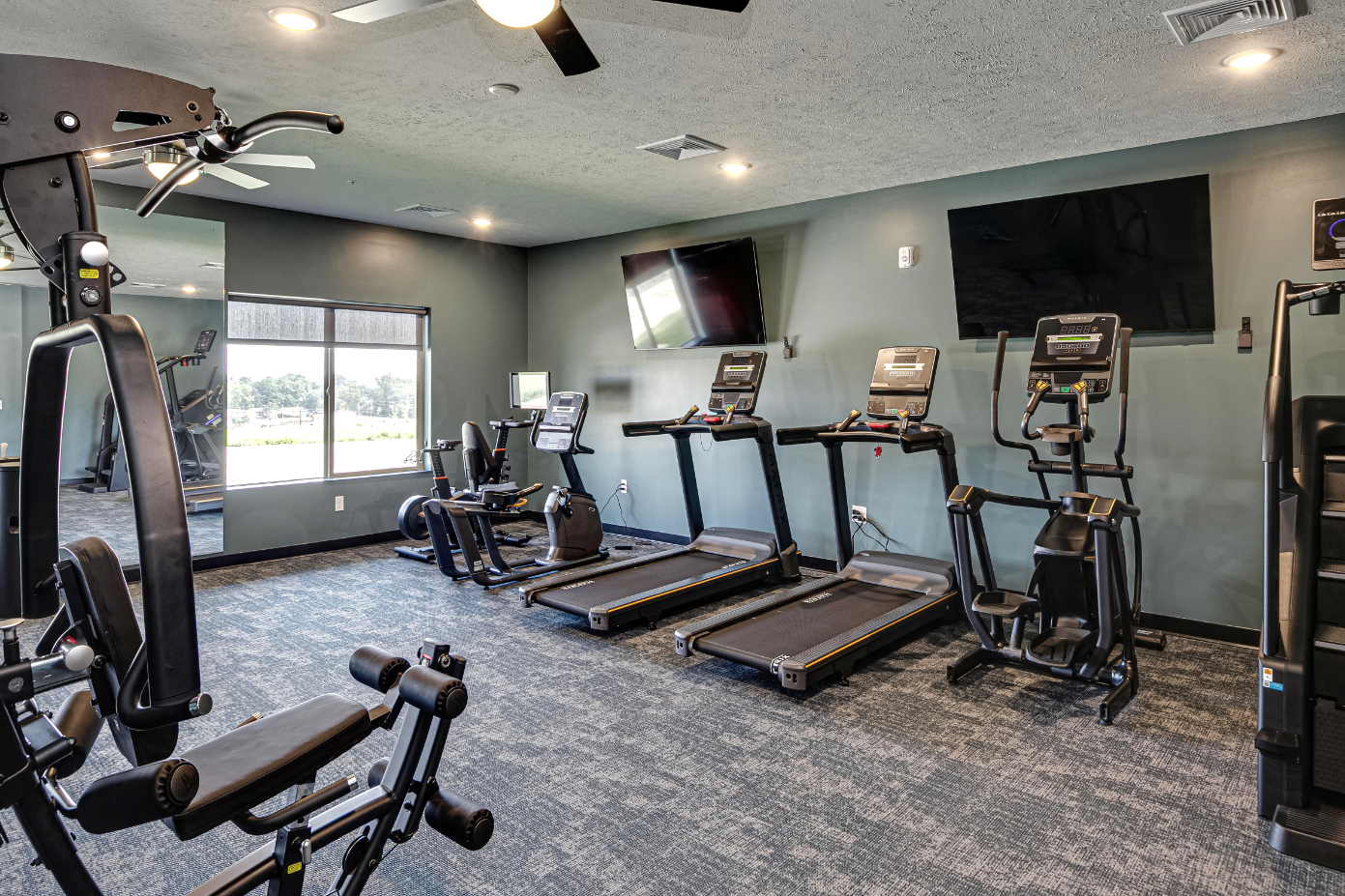 Clubhouse gym with treadmills, stair master, and stationary bike