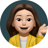 Cartoon avatar of a woman with brown hair wearing a yellow jacket and waving.