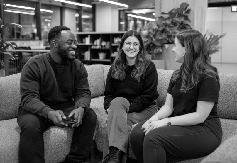 Team Chatting On Office Sofa During Casual Meeting PromptEngine Webflow Template | BRIX Template