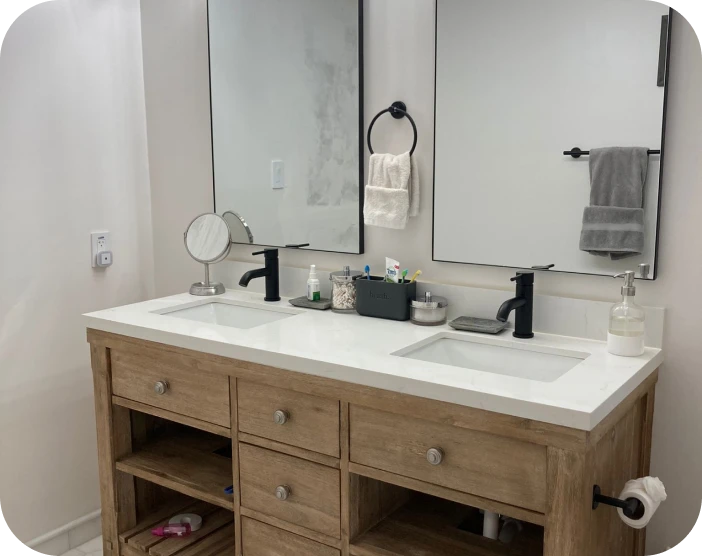 Modern bathroom vanity with dual sinks, black faucets, two rectangular mirrors, and wooden cabinet with drawers.