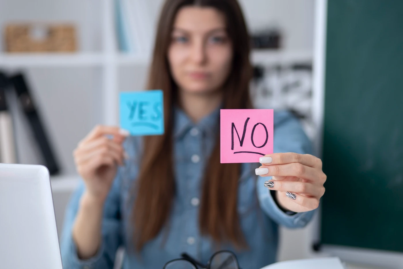 Person holding blue sticky note with 'YES' and pink sticky note with 'NO' in front of them.