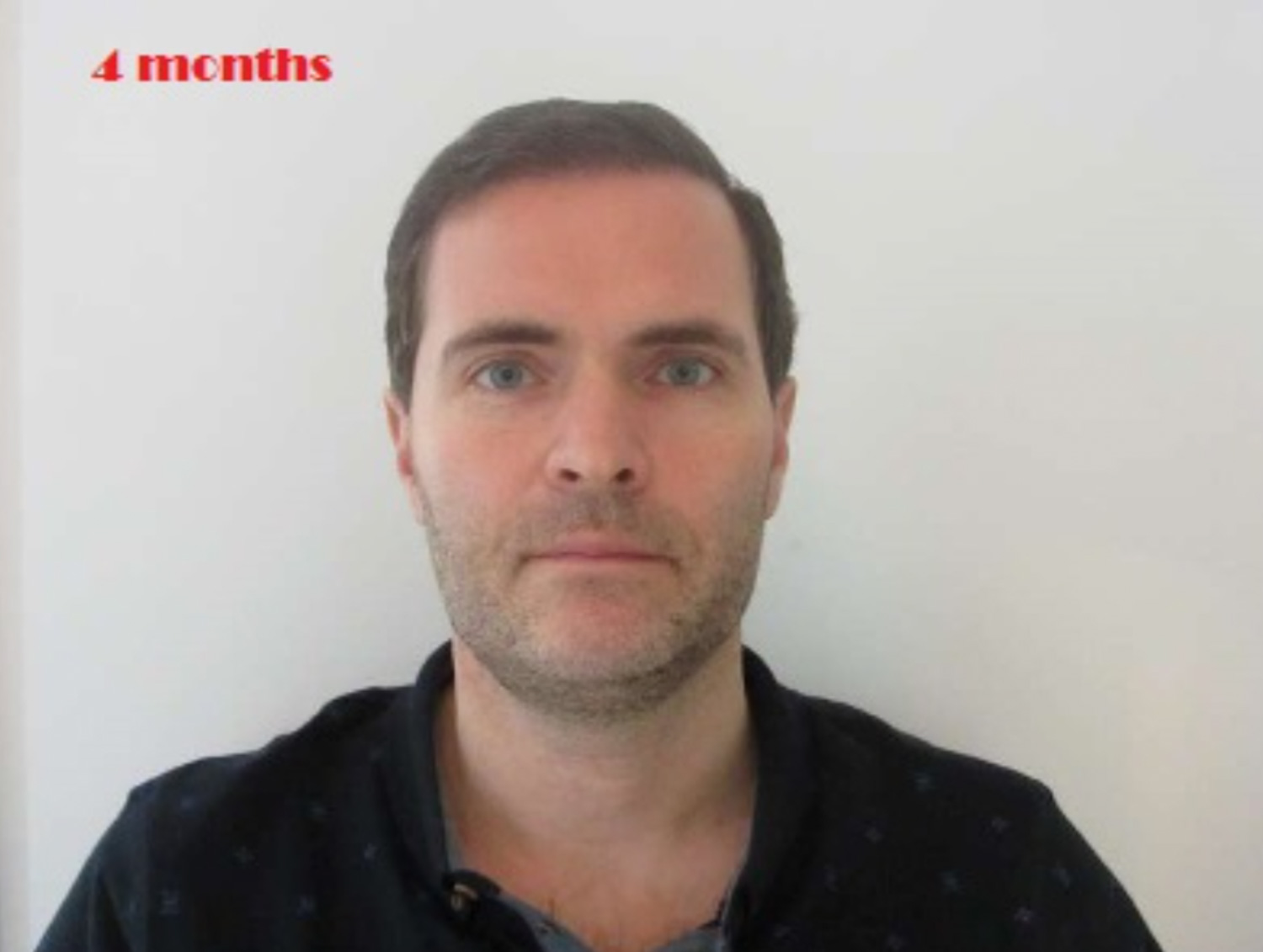 A man with short hair and stubble beard faces the camera against a plain white background.