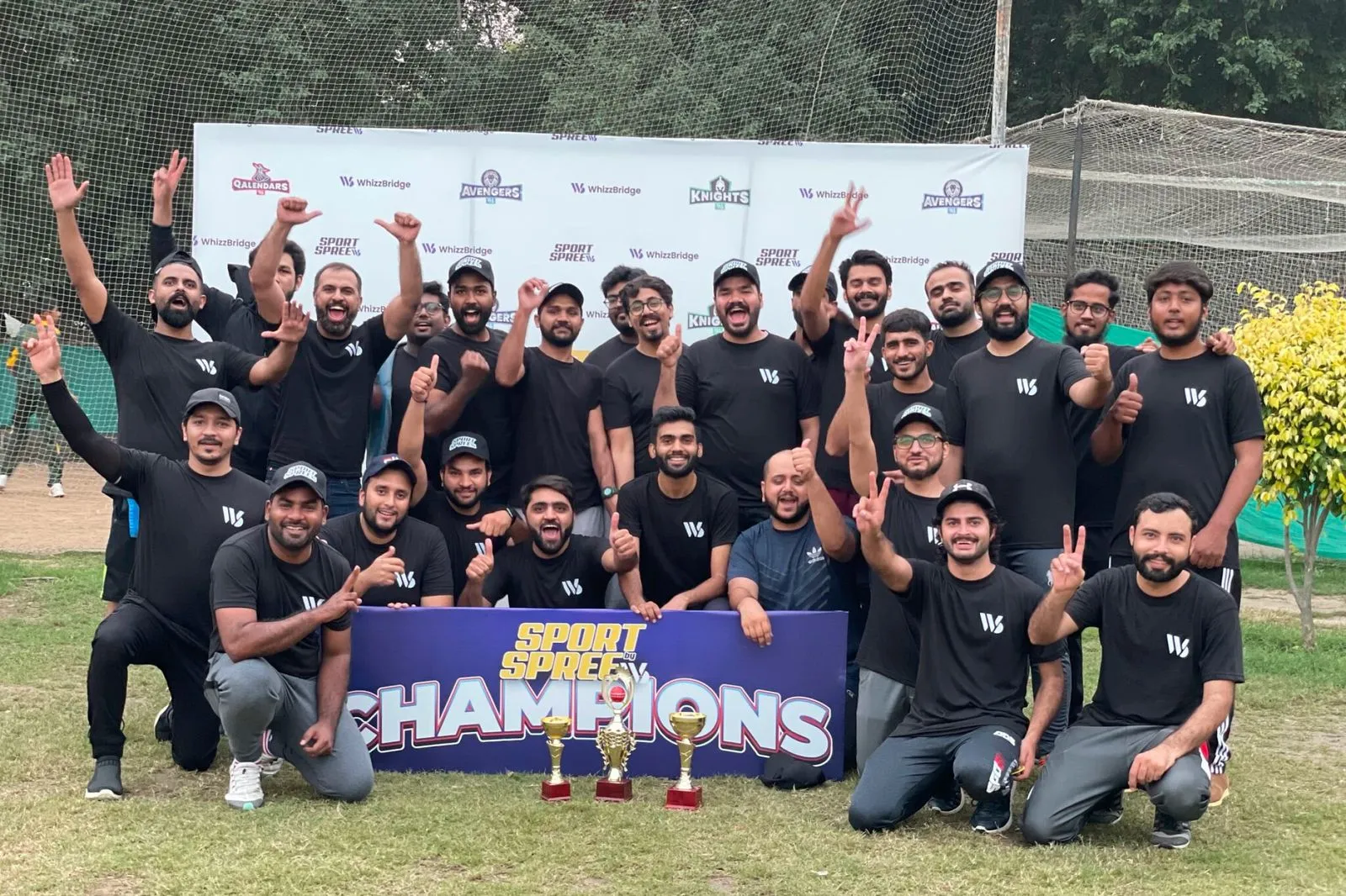 The team smiles proudly as they pose together, holding their trophy in celebration of their victory.