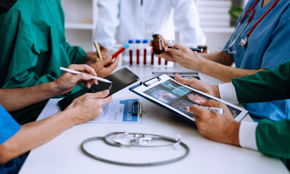Healthcare professionals engaged with a tablet in a meeting, highlighting a case study on seamless cloud application handover.