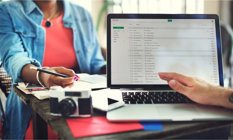 A person engaged with a laptop showing a case study document on "Design for an AI-powered email plugin" in the SaaS sector.