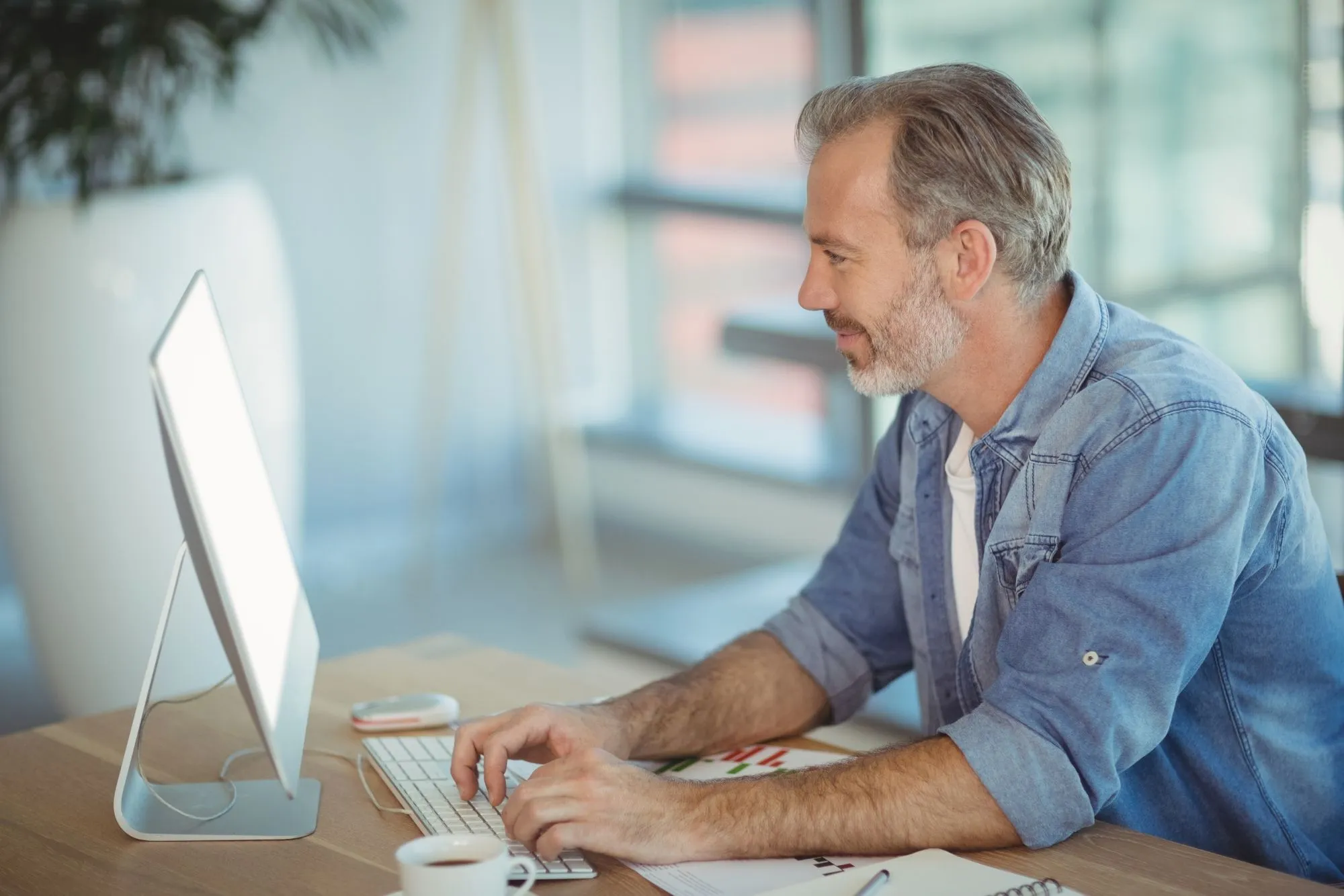  A man at a desk with a computer, illustrating the role of a Fractional CTO in optimizing business technology.