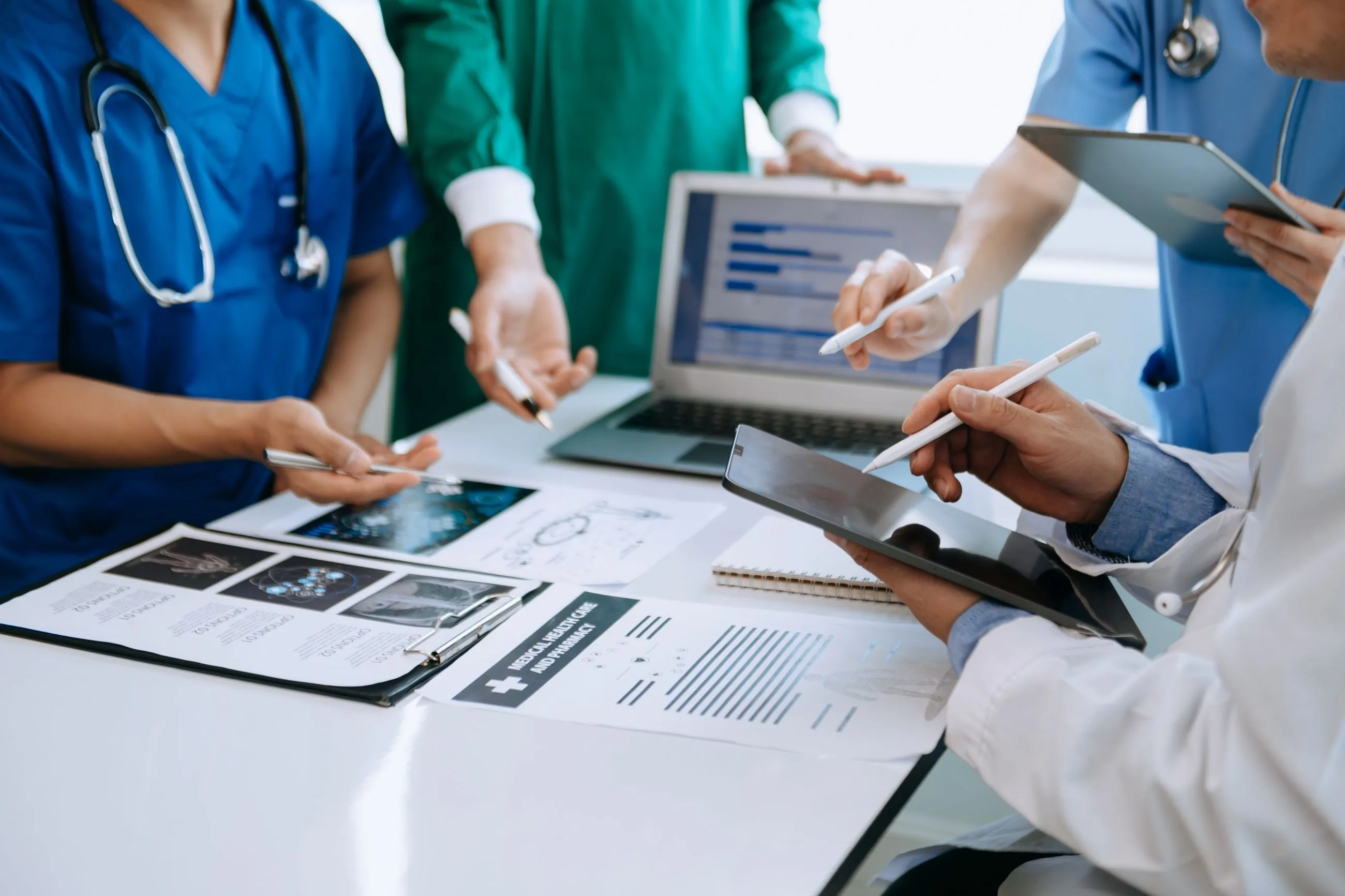 Medical team collaborating on a laptop, focusing on data migration to Salesforce for improved healthcare data management.