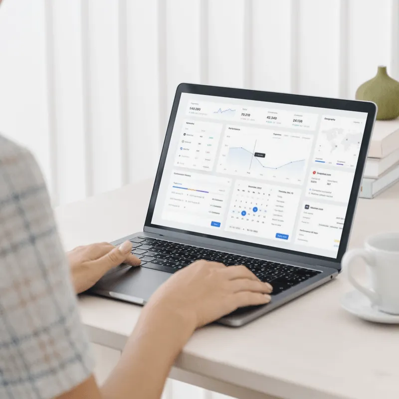 A woman interacts with a laptop featuring a dashboard, illustrating the new website which focus on language localization and user experience.