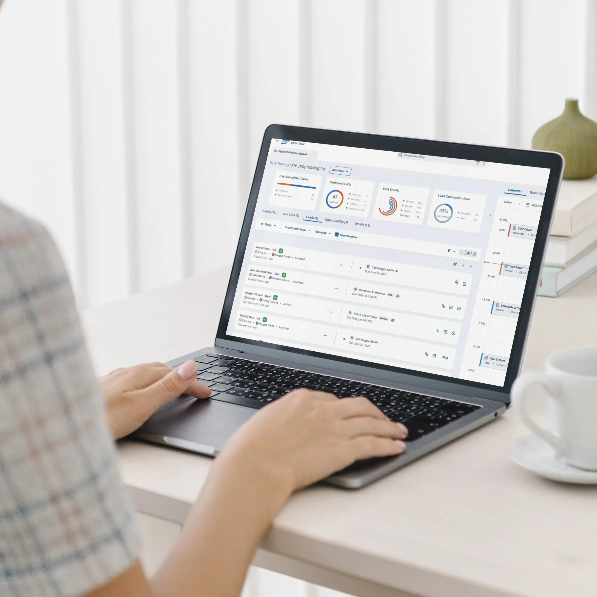  A woman uses a laptop showing a dashboard related to integrated revenue.