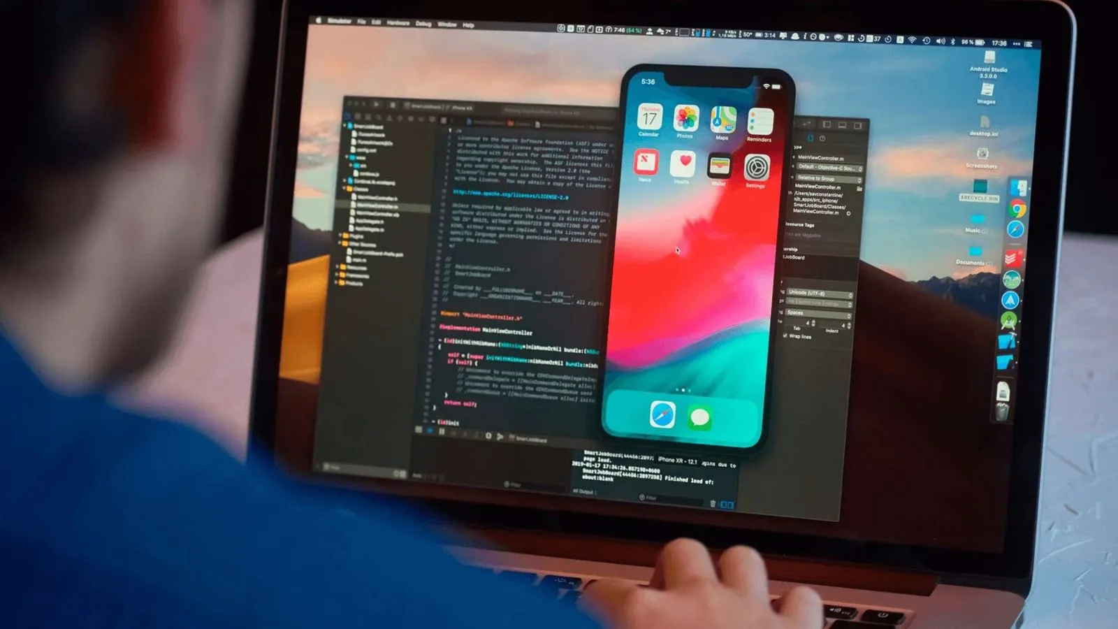 A person interacts with an iPhone displayed on a laptop screen, showcasing a fitness app developed by Whizzbridge.