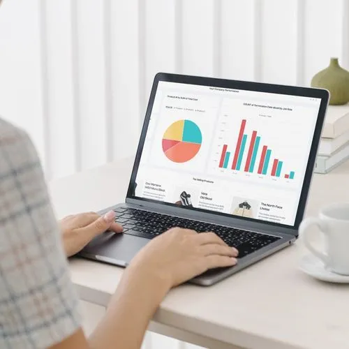 A woman works on a laptop displaying a chart, focusing on data analysis and optimization strategies for simulations.