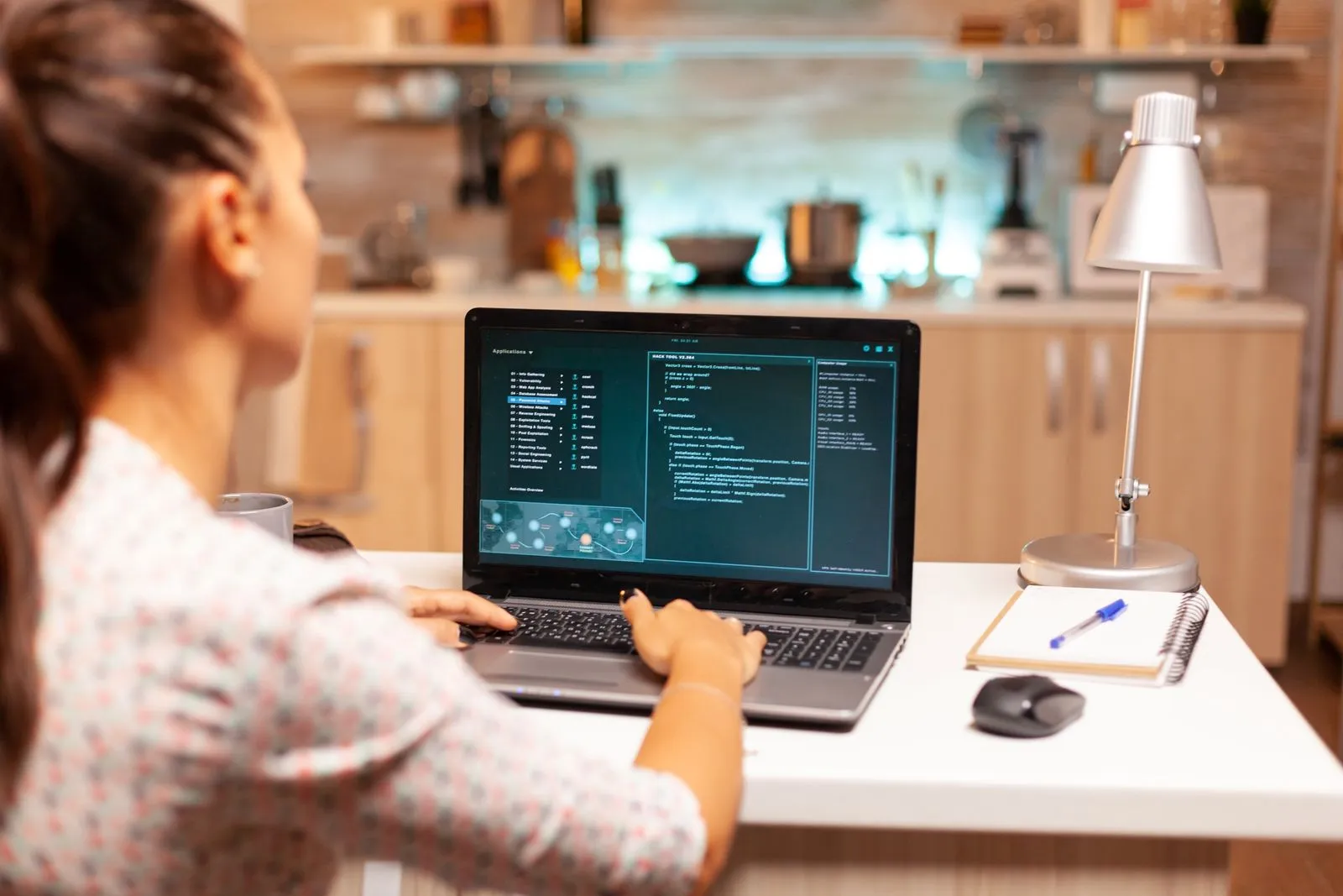 A woman sits in her kitchen, focused on her laptop, representing the blend of home and work life in the digital age.