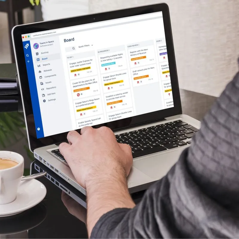  A person using a laptop to view a calendar, indicating project planning and scheduling for tech initiatives.