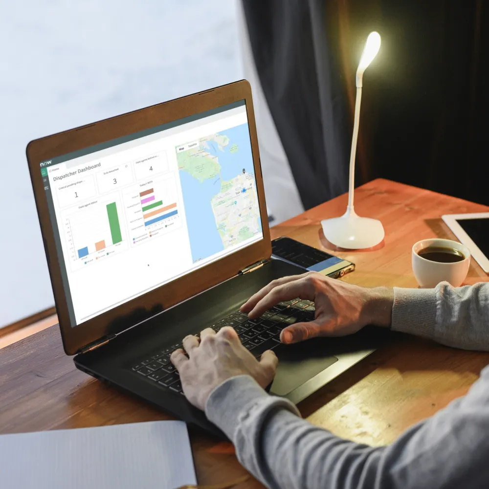 A man is focused on a laptop showing a map, highlighting WhizzBridge's automated task assignments and technician routing system.