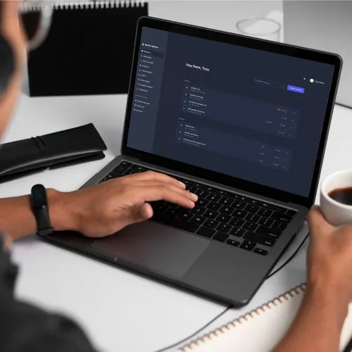 A person working on a laptop displaying a desktop app for automated data synchronization and dynamic pricing features.