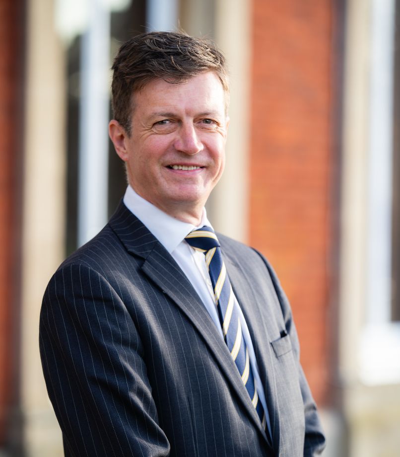 Headteacher smiling in the school grounds
