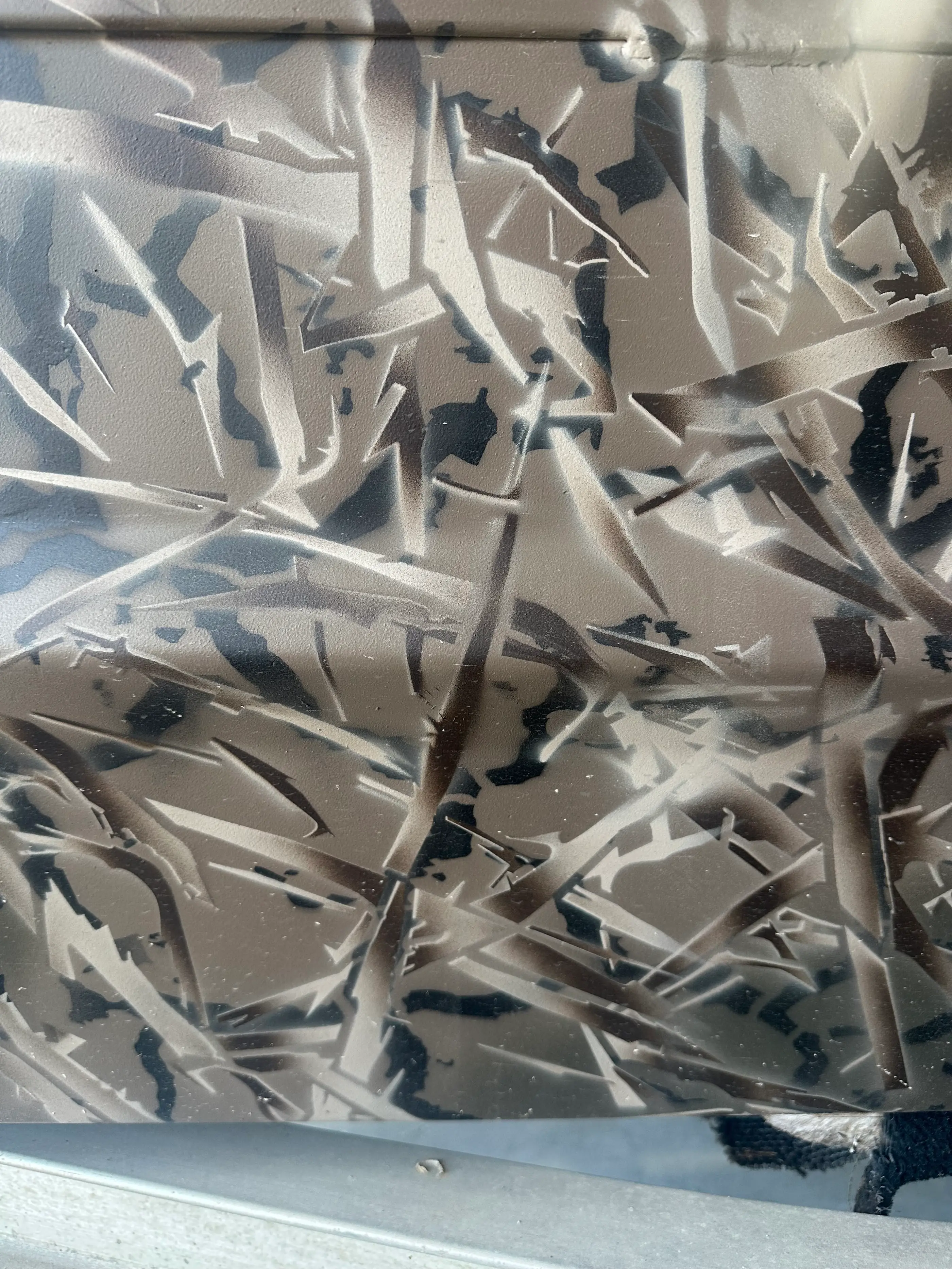 Close-up of a patterned surface with abstract sharp, angular shapes in shades of gray and black.