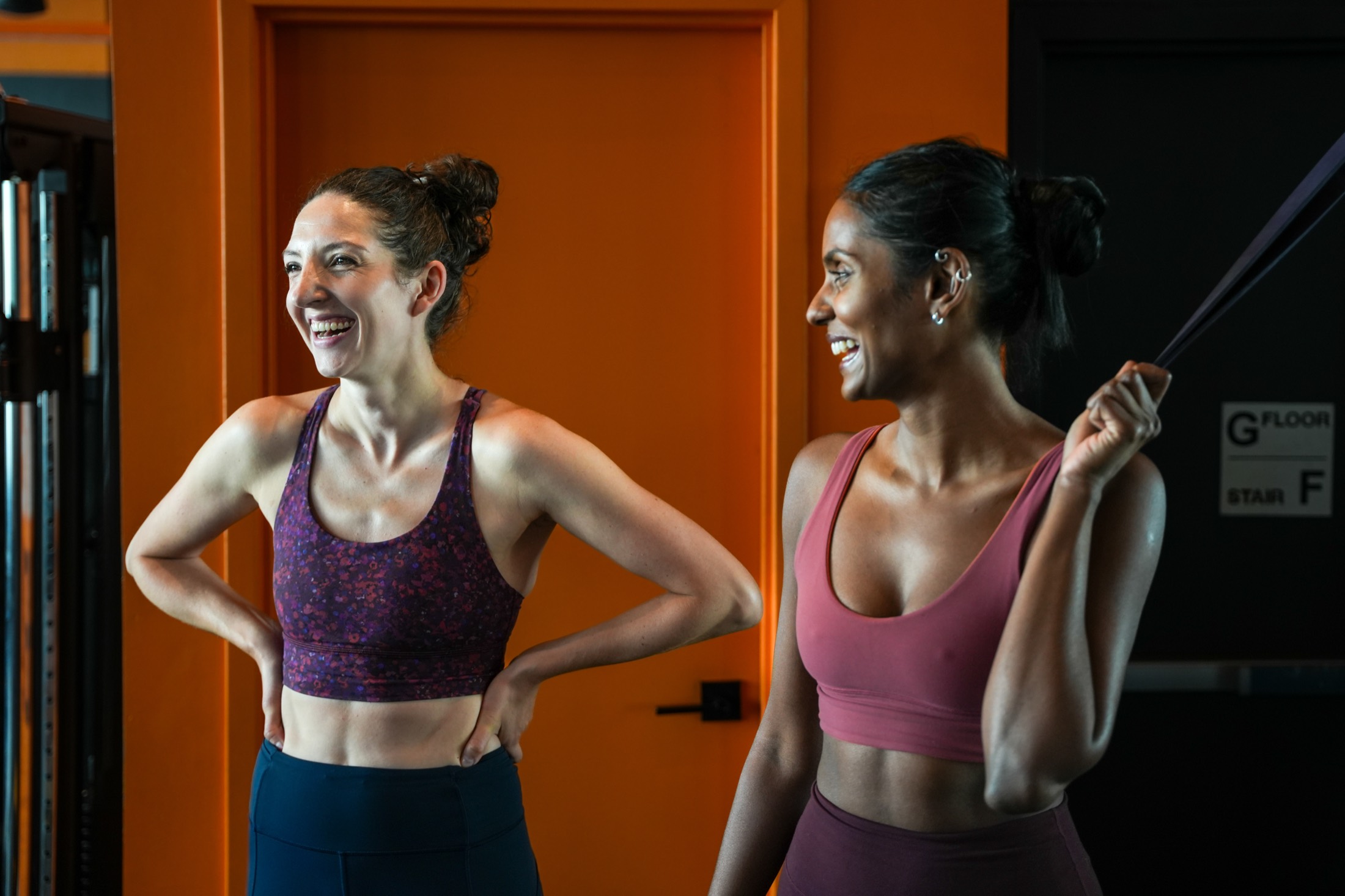 Two Fit Factory members laughing together between sets