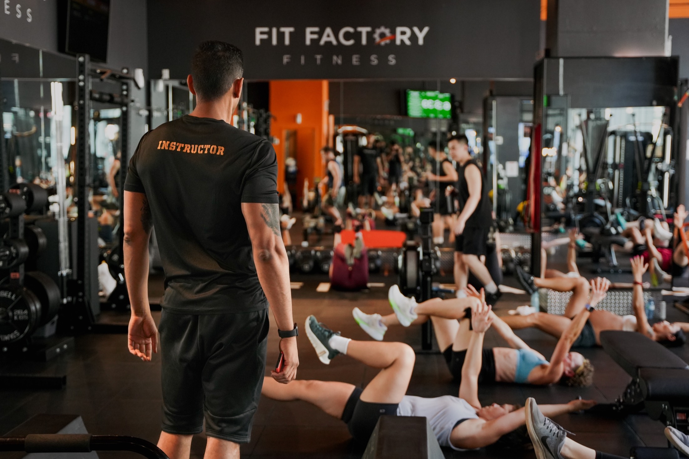 A Fit Factory coach leading a packed group fitness class in Toronto
