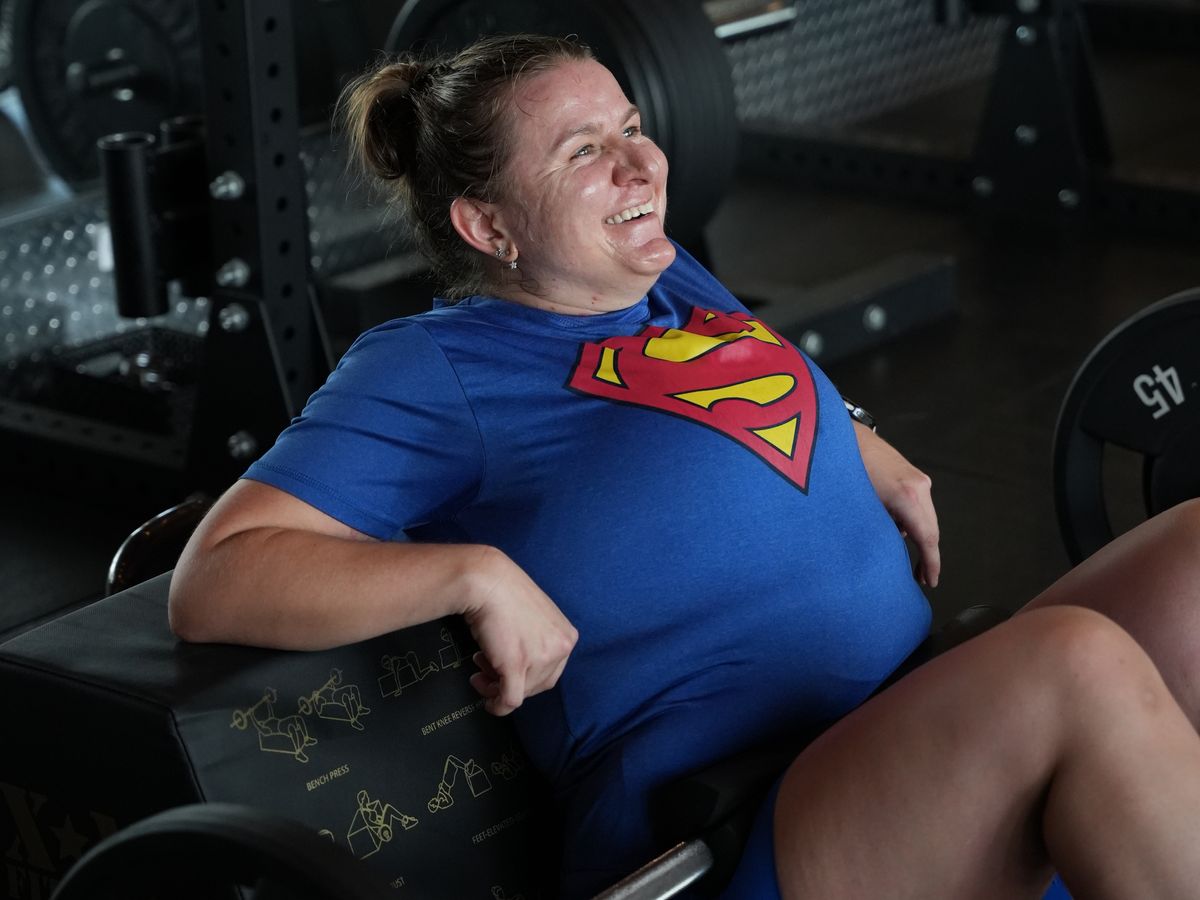 A member laughs mid hip thrust during a strength class at Fit Factory Midtown