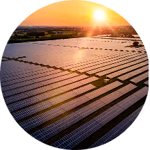 Aerial view of a solar farm with rows of solar panels capturing sunlight during sunset.