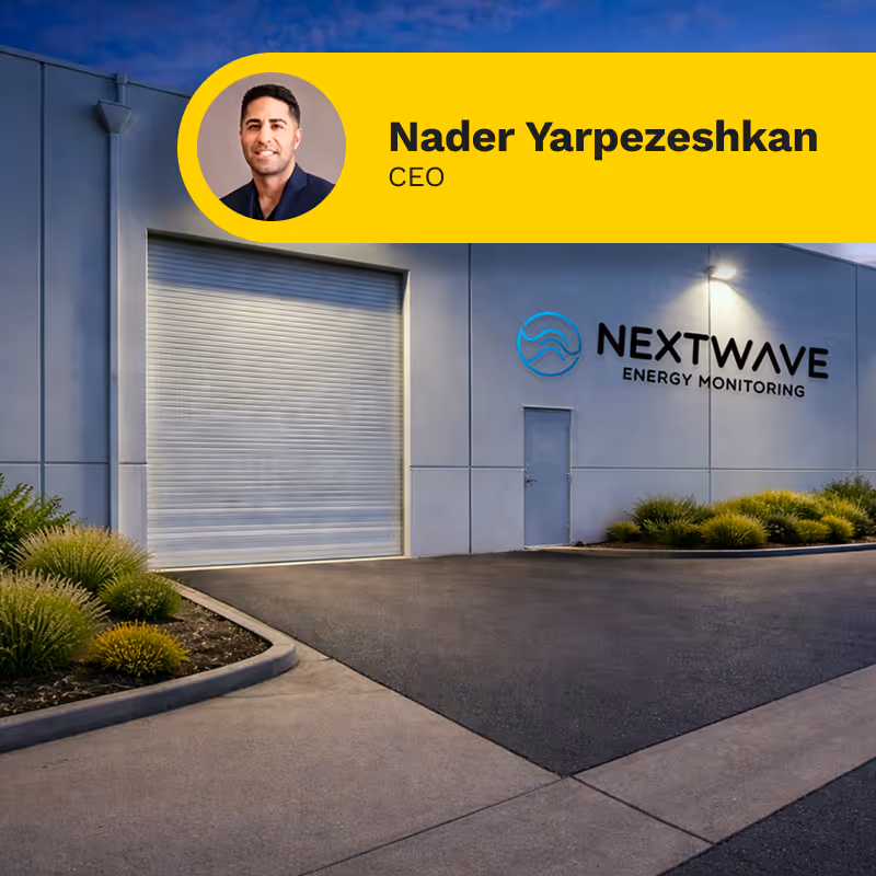Industrial building exterior at dusk with Nextwave Energy Monitoring logo and CEO Nader Yarpezeshkan's photo and title in a yellow banner.