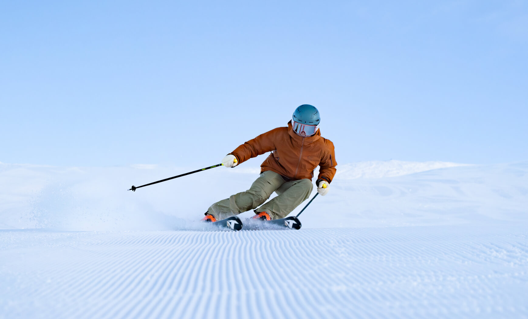 Skier carving on freshly groomed corduroy at Mt Hutt on a clear day