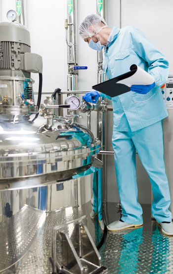 Pharmaceutical cold chain storage worker in blue lab suit