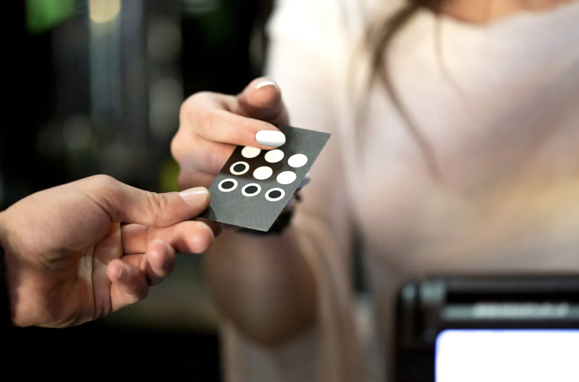 Customer handing over a punch card at a bubble tea counter