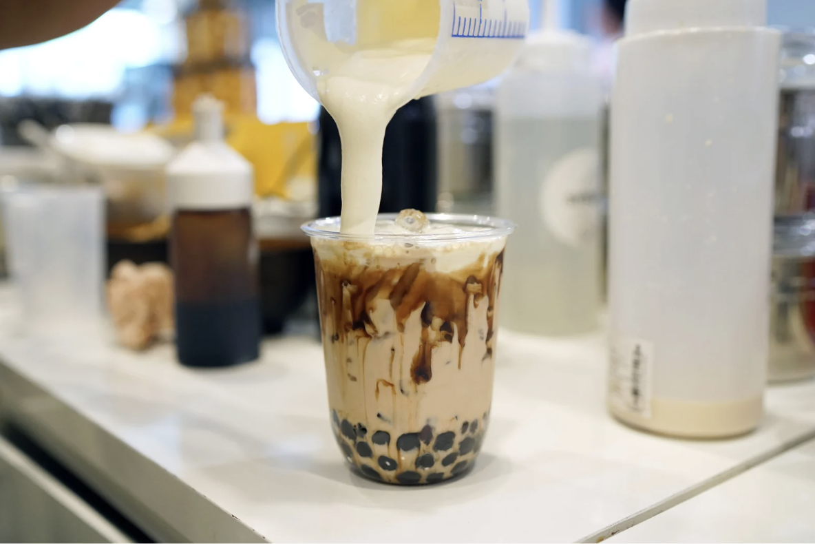 Freshly brewed brown sugar milk tea being poured into a cup