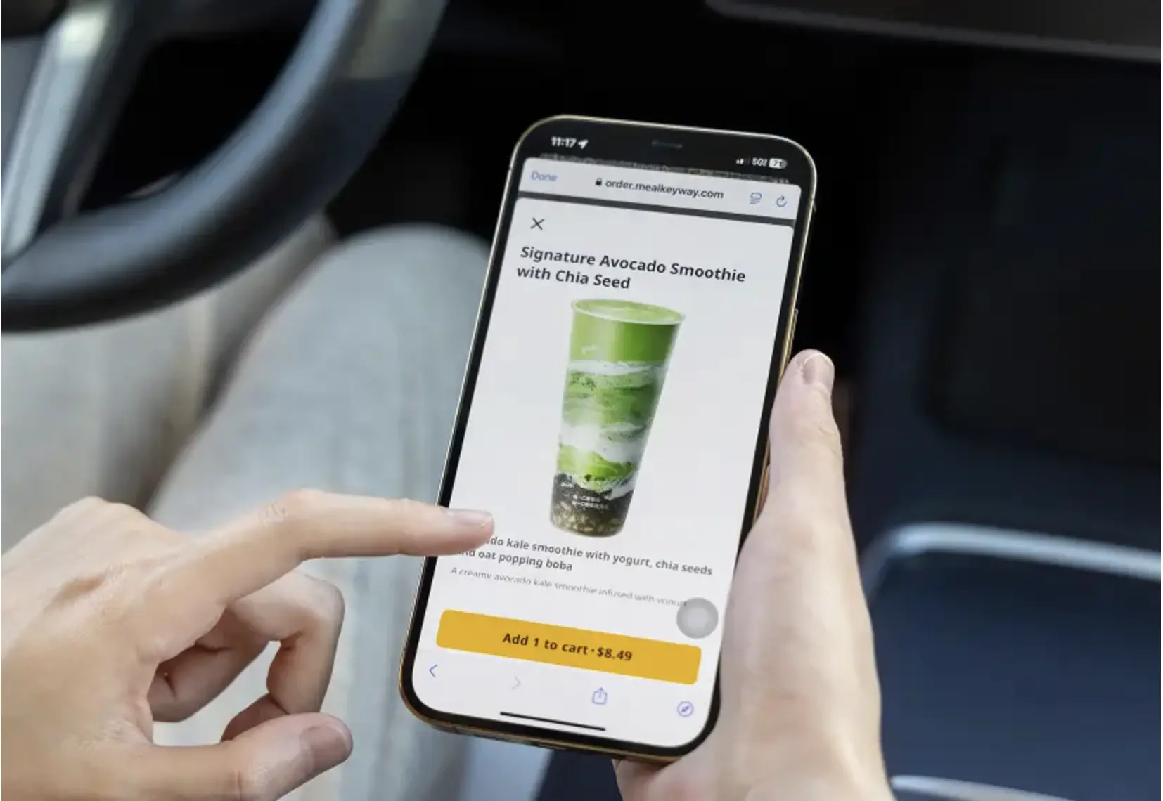 A customer uses the MealKeyway app on a smartphone to order a Signature Avocado Smoothie with Chia Seed through an online restaurant menu.