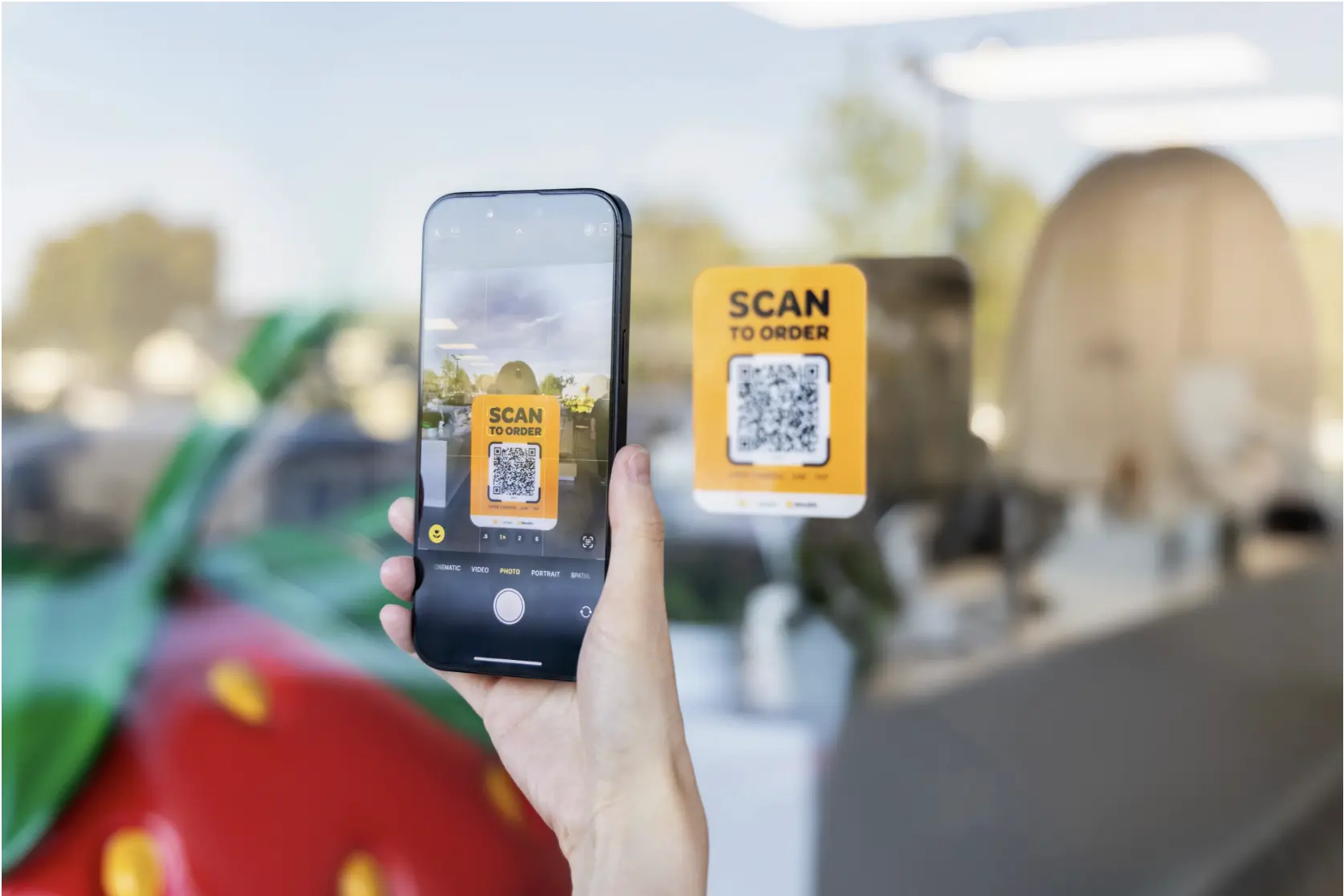 Customer scanning a “Scan to Order” QR code on a restaurant window to place an order using MenuSifu’s self-ordering system.