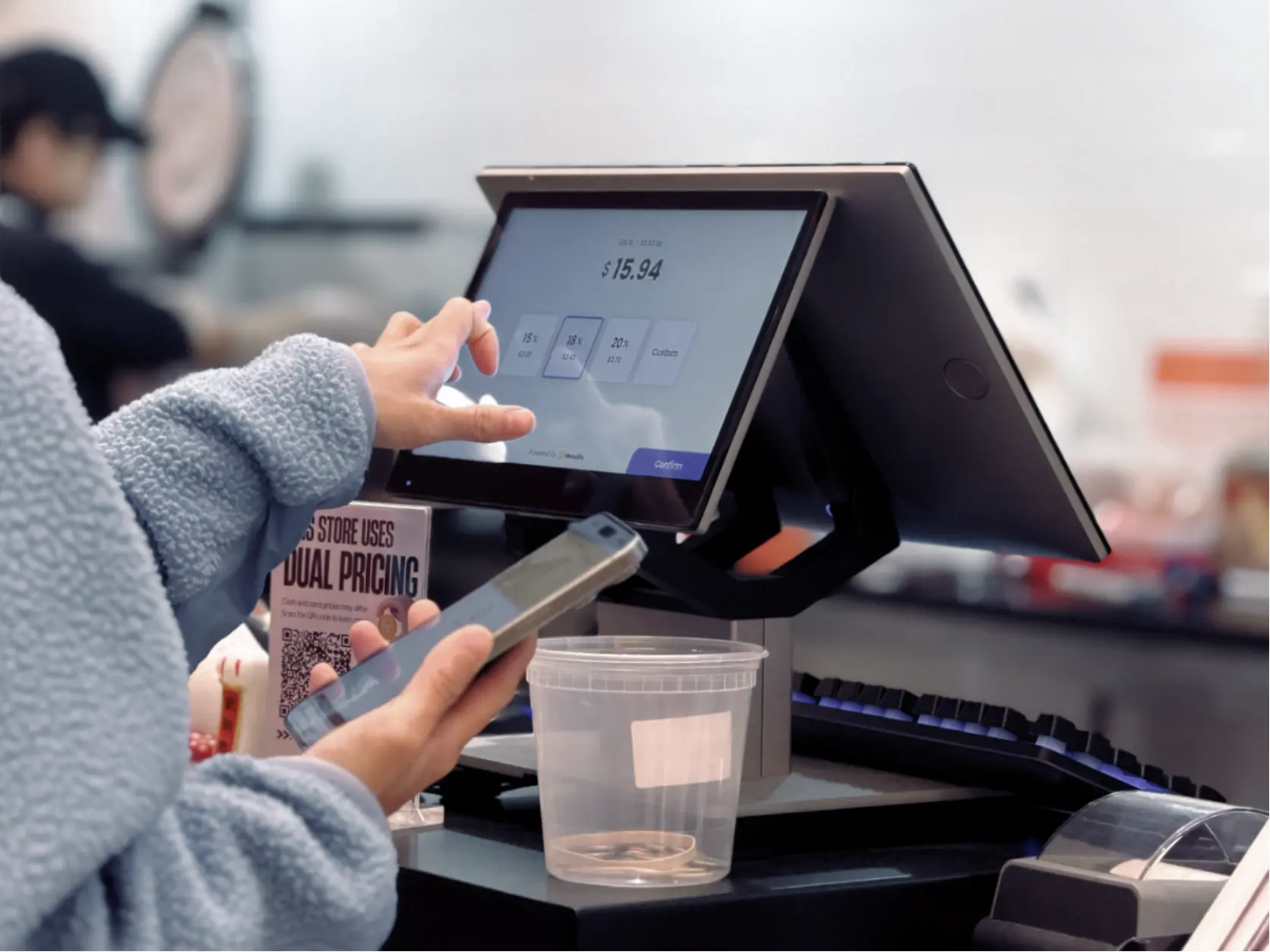 A restaurant customer uses the MenuSifu POS touchscreen to complete checkout and payment efficiently.