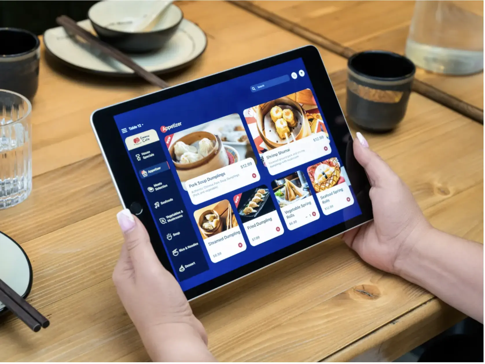 A restaurant guest using the MenuSifu tablet ordering system at the table to browse dishes and place an order through the digital menu interface.
