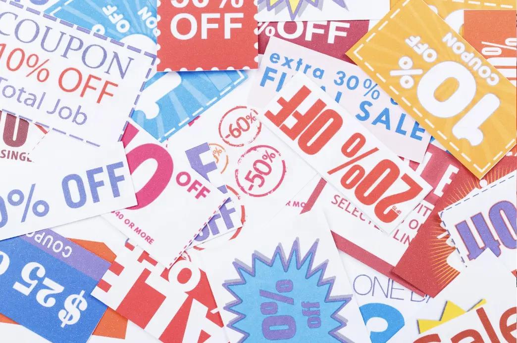 A variety of colorful printed coupons with different discount percentages like 10%, 20%, and 50% off.