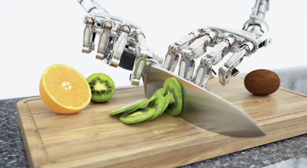 A robotic hand using a knife to slice fresh fruits, showcasing AI-driven automation in restaurant kitchens.