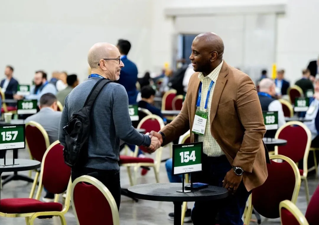 Two attendees shaking hands during a business meeting at Fintech Meetup 2026.