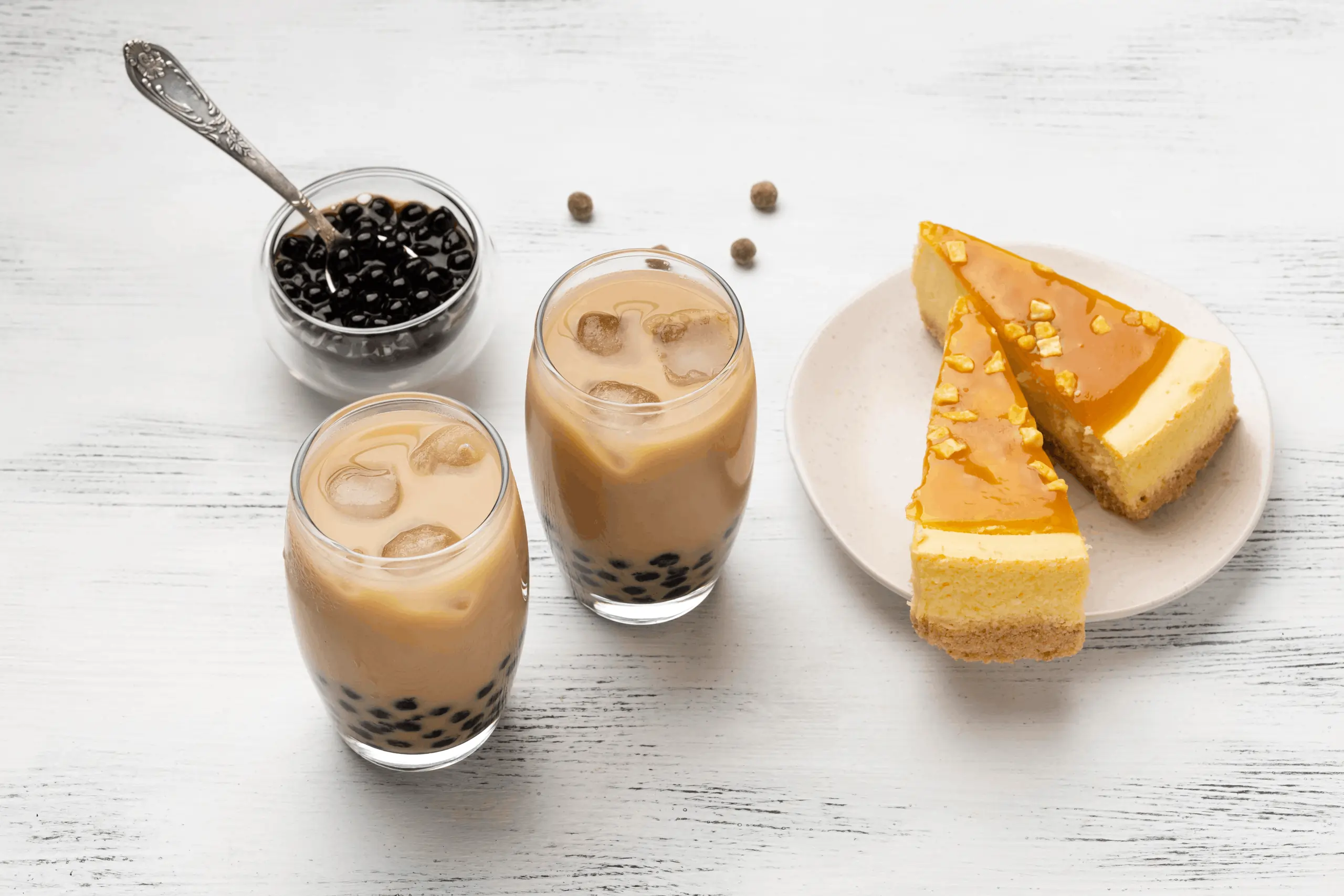Tapioca pearl milk teas and caramel cake slices displayed, perfect combo served effortlessly using bubble tea POS system tools.