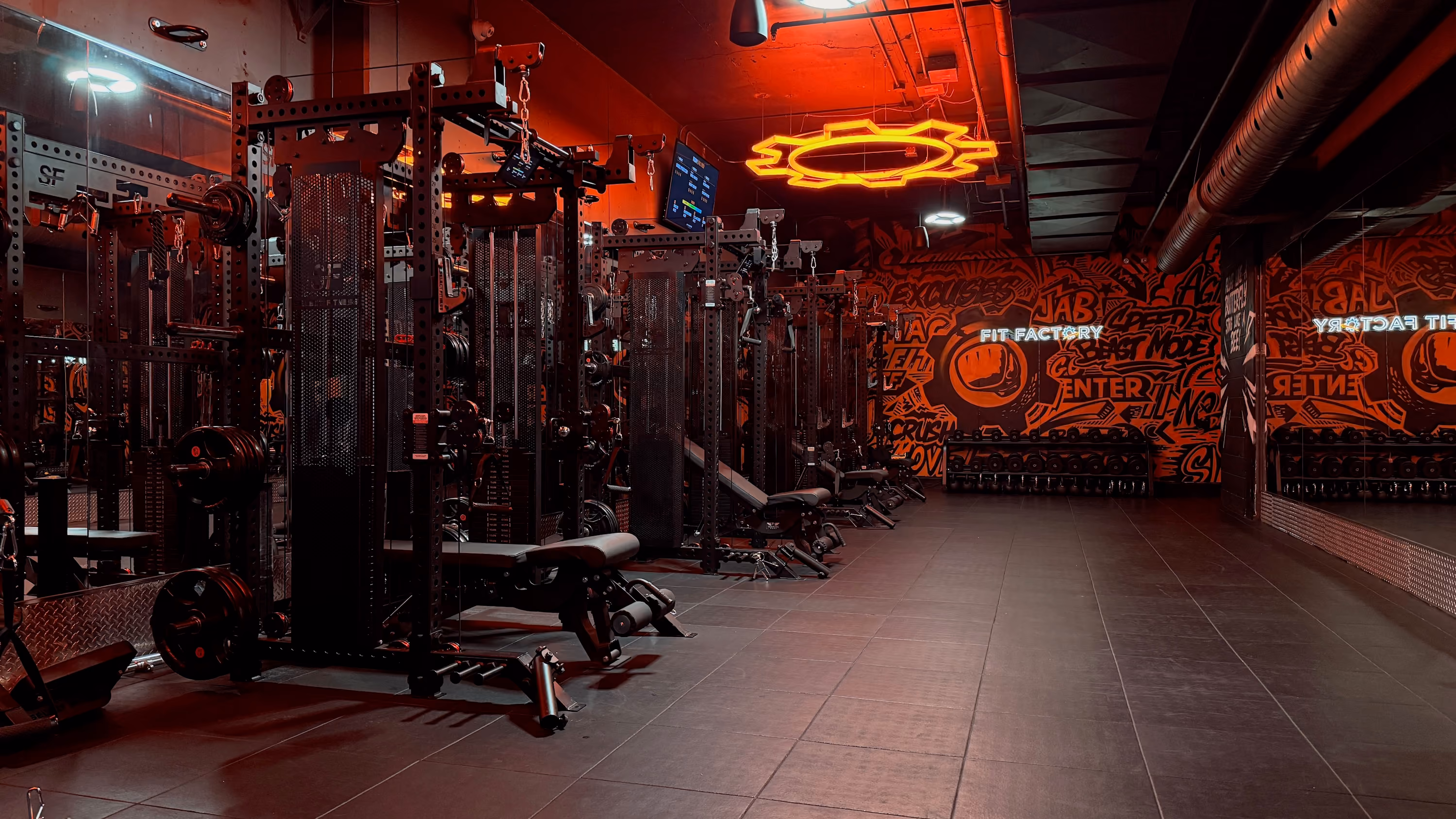 The Fit Factory Downtown strength floor with squat rigs and branded walls