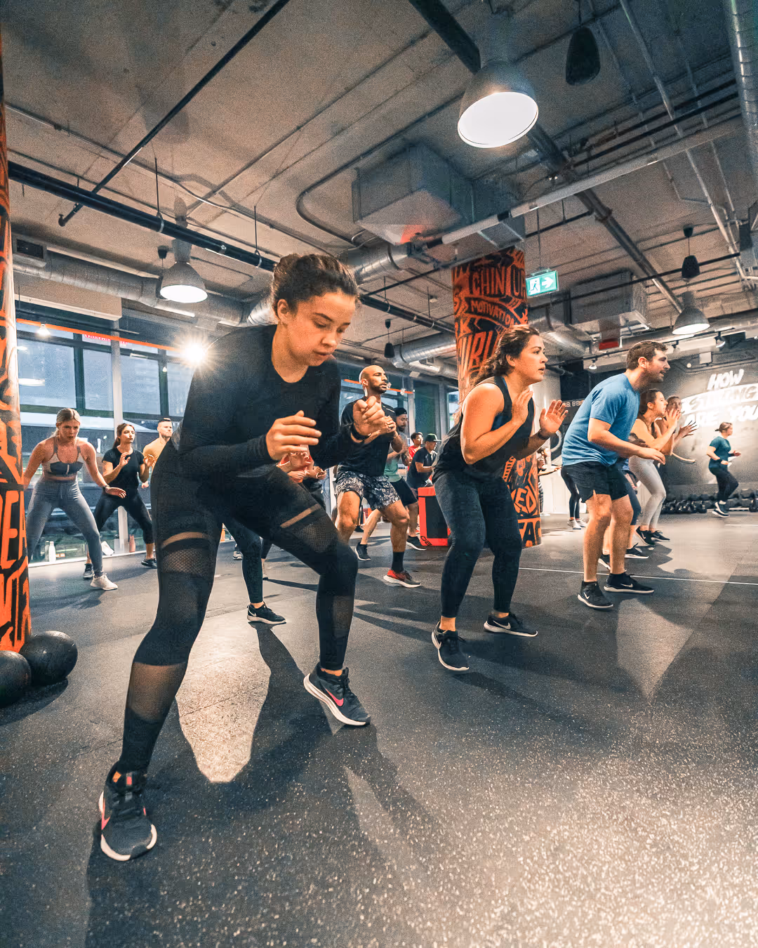 Members moving through a lateral lunge drill in a coach-led conditioning class