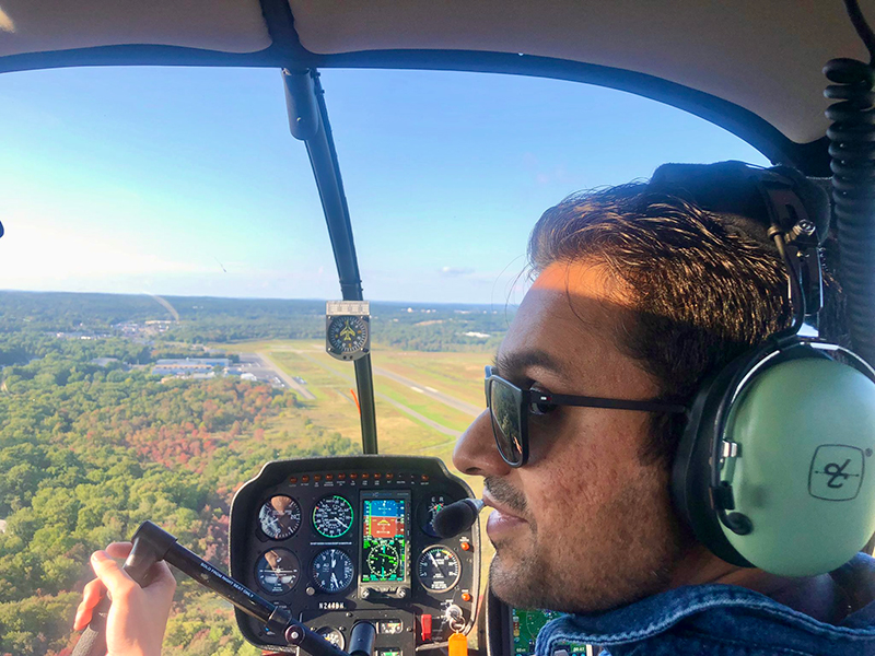 Ash with aviation headset, piloting a helicopter